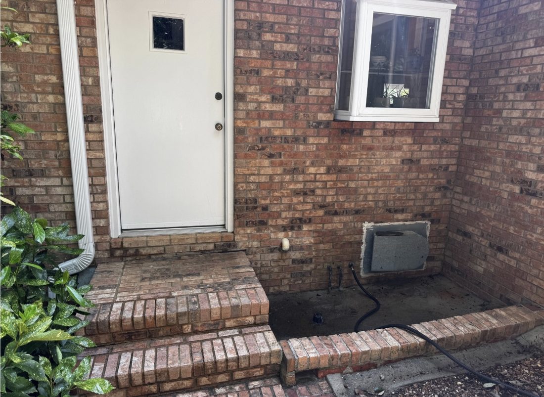 The same brick steps after cleaning, with the moss removed and the original brick color visible