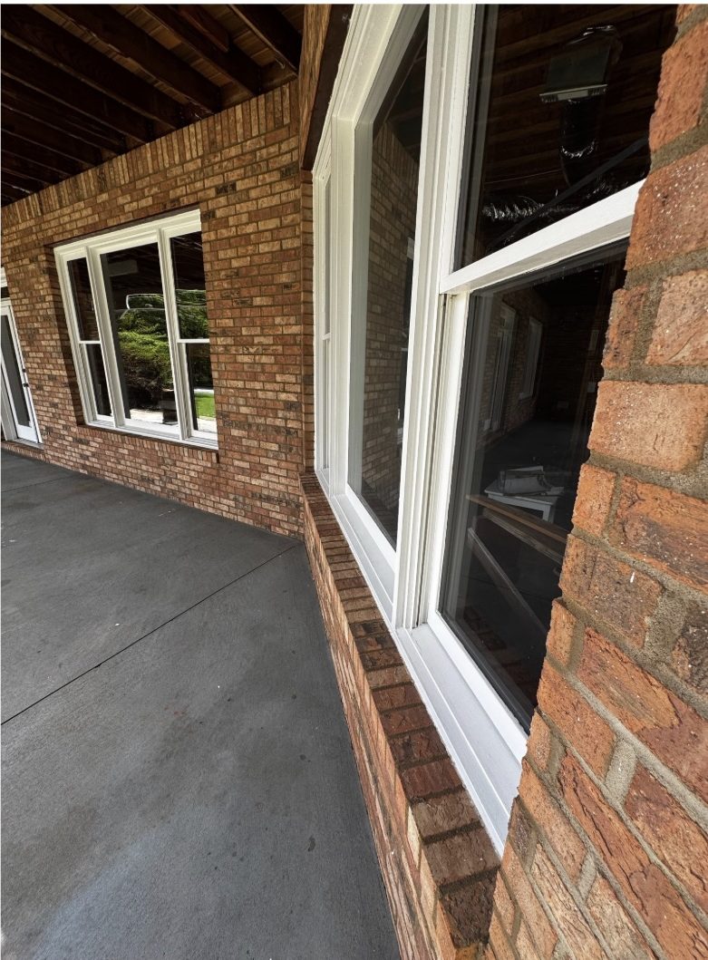 The same brick, window trim and walkway after a low-pressure soft wash, with the brick color clear and the trim clean white
