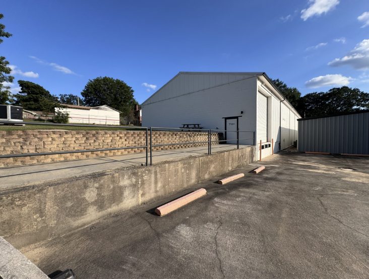 Stained concrete loading dock, retaining wall and parking area at a commercial building before pressure washing