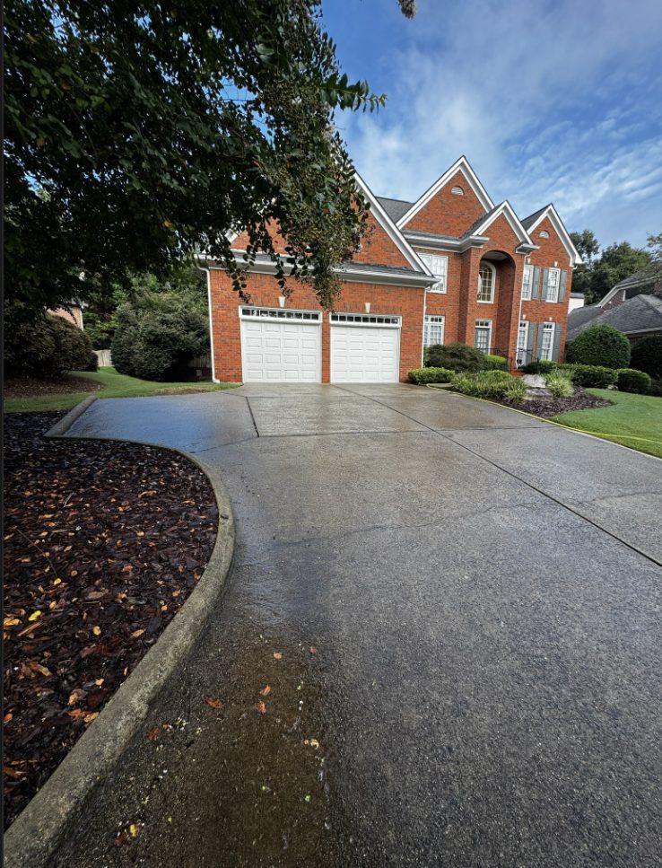 Dirty stamped concrete driveway covered in algae and mildew at a brick home in the East Hampton neighborhood of Marietta, Georgia, before pressure washing