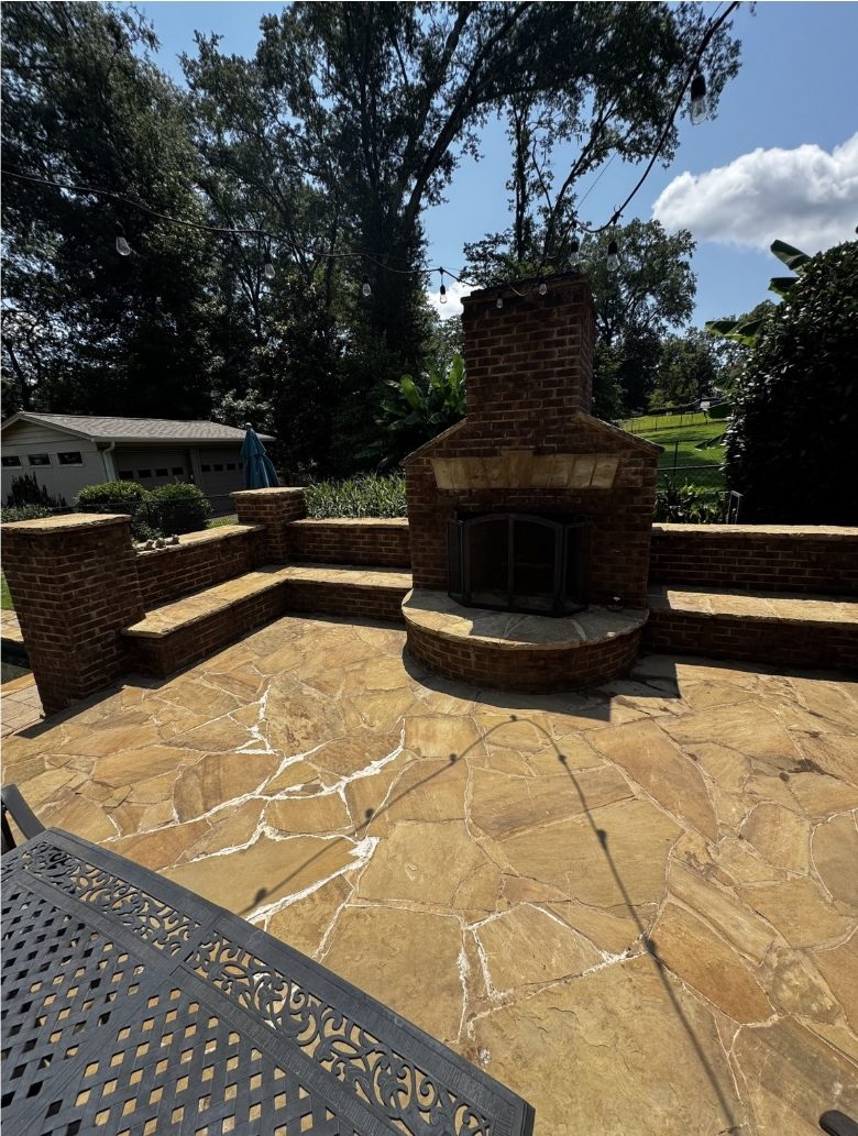 The same flagstone patio and brick fireplace after cleaning, with the natural gold and tan stone color fully restored